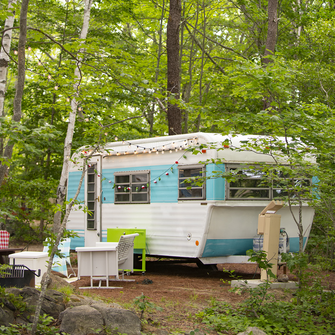 vintage camper on wooded campsite